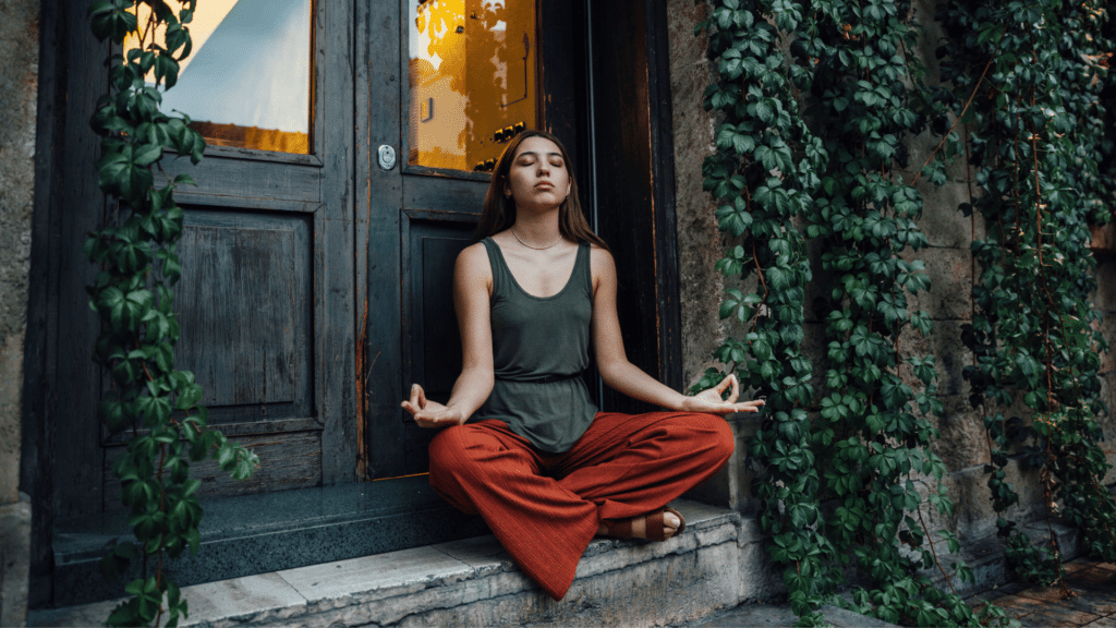 Mulher meditando em frente a uma porta 