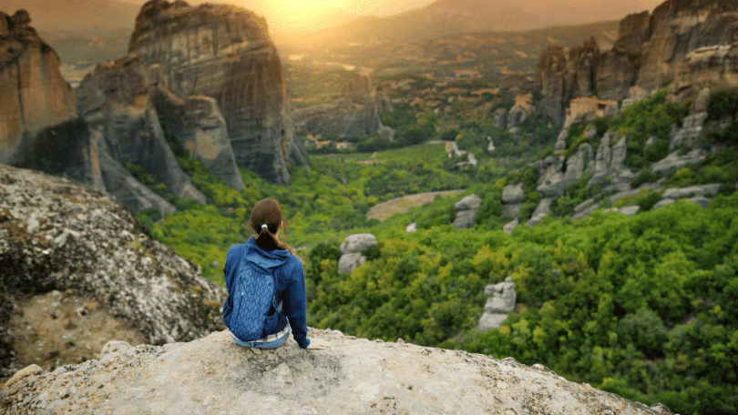 Mulher explorando a natureza em cima de uma montanha