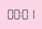 Horário 00h01 escrito em letras de relógio digital sobre um fundo cor de rosa
