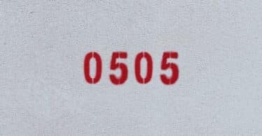 Número 0505 estampado de vermelho numa parede branca