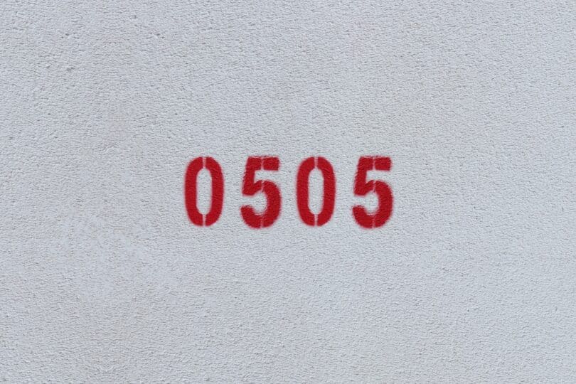Número 0505 estampado de vermelho numa parede branca