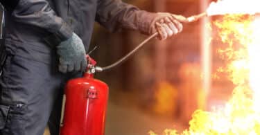 Homem apagando fogo com extintor
