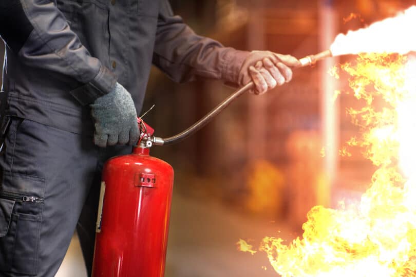 Homem apagando fogo com extintor