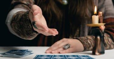 Imagem de uma taróloga apontando para as cartas de tarô