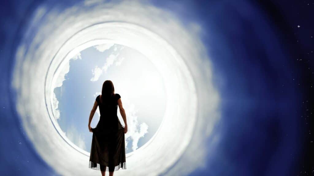 Imagem de uma mulher de vestido entrando em um portal que liga ao céu