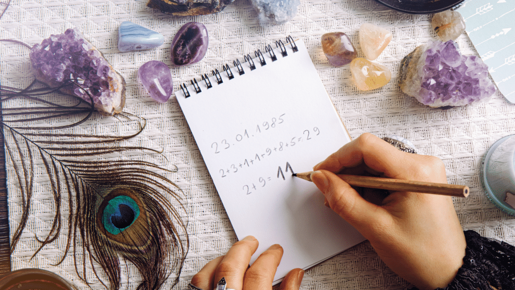 Mulher calculando a numerologia, ao lado de cristais e outros itens místicos.