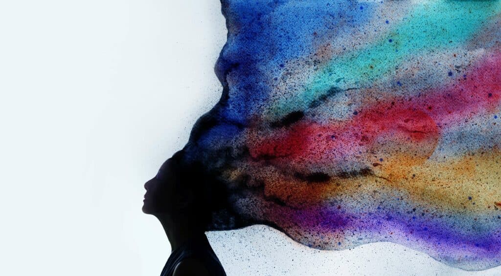 Silhueta de uma mulher, cuja cabeça se desfaz em uma fumaça colorida.
