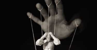 Mão controlando uma marionete