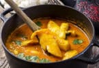 Peixe cozido dentro de uma panela com molho curry