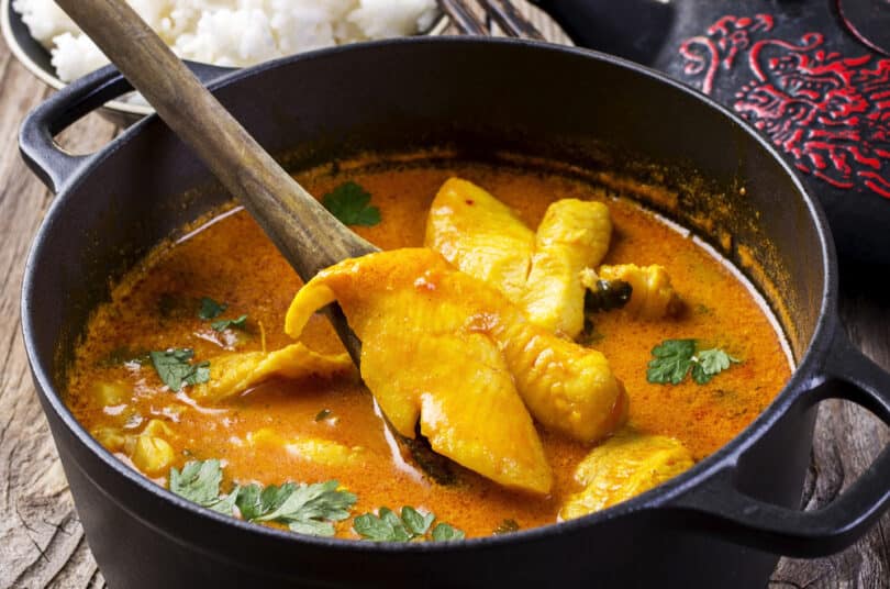 Peixe cozido dentro de uma panela com molho curry