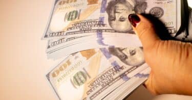 Mulher contando várias notas de dinheiro falso nas mãos