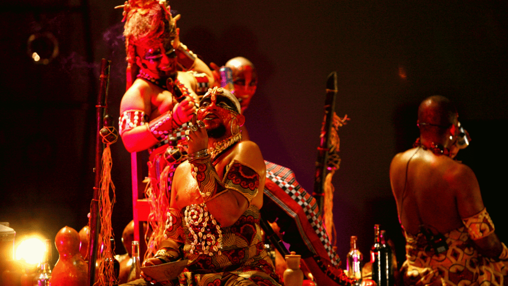 Pessoas vestidas de Exu em encenação teatral