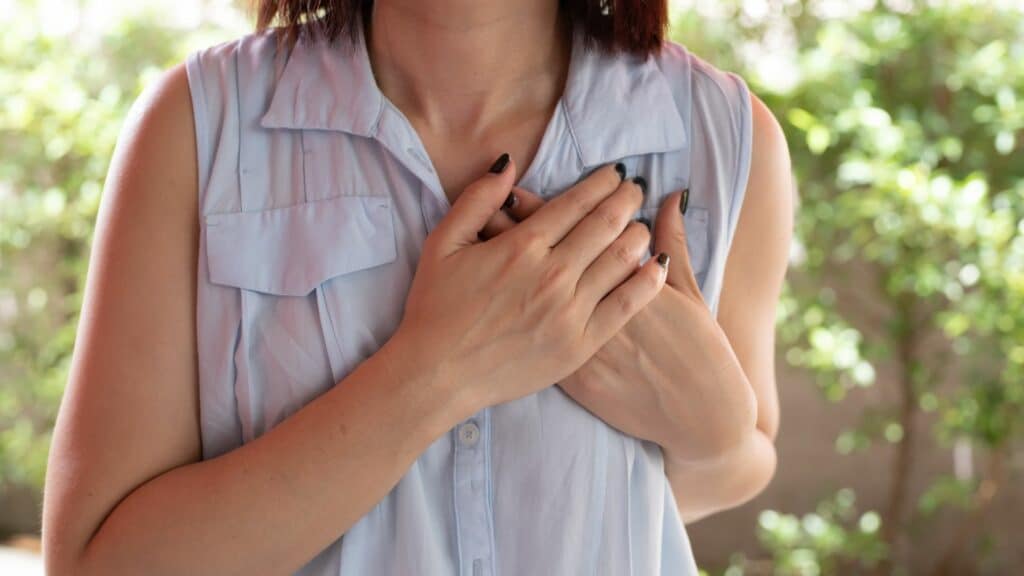 Imagem de uma mulher com as mão direcionadas ao coração