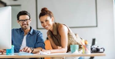 Imagem de dois colegas de trabalho lado alado no escritório