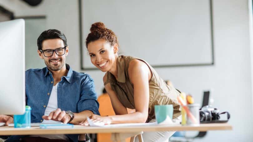 Imagem de dois colegas de trabalho lado alado no escritório