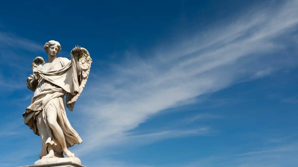 Imagem de uma estátua de anjo perto do céu azul