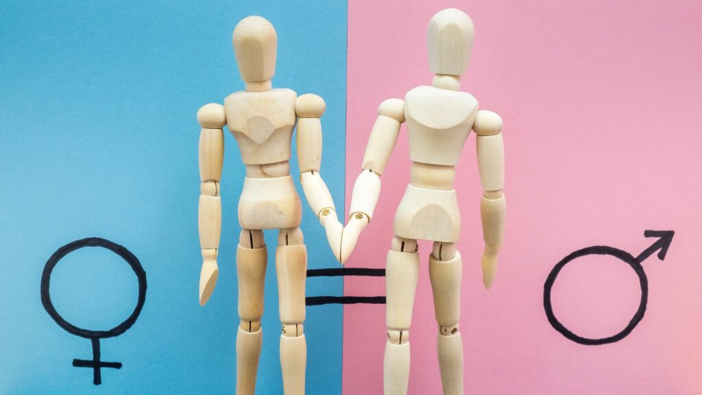 Cenário de bonequinhos de manequim dando as mãos em pró da igualdade de gênero. 