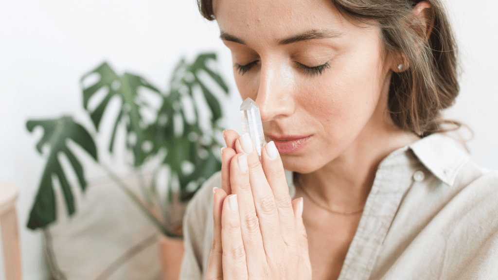 Mulher meditando com cristal em suas mãos