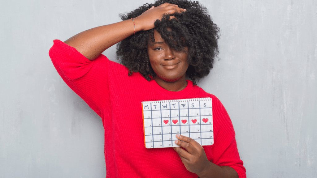 Mulher segurando calendário menstrual