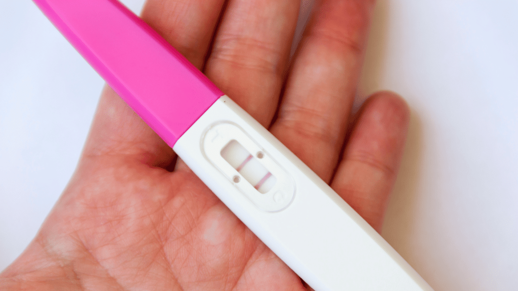 Pessoa segurando teste de gravidez positivo 