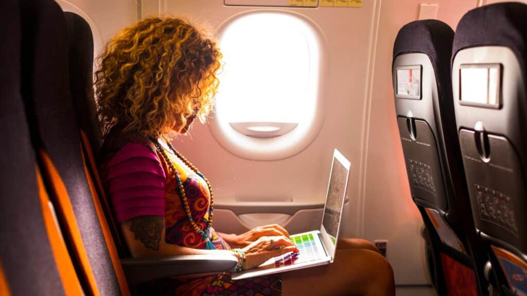 Mulher mexendo no computador no avião.