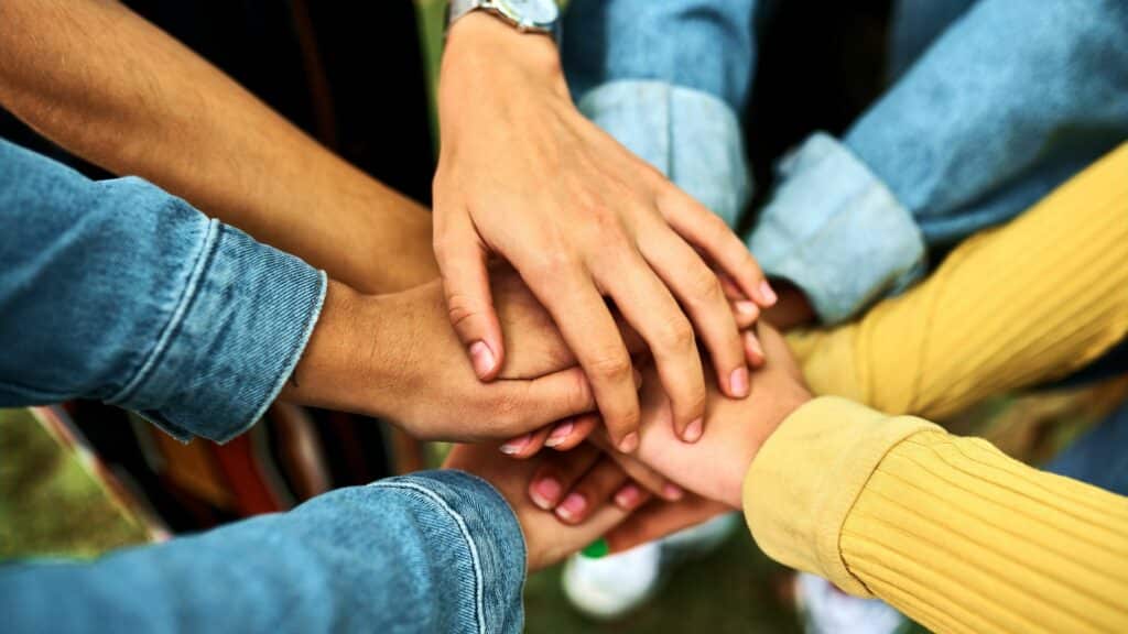 Mãos de várias mulheres umas sobre as outras em sinal de união.