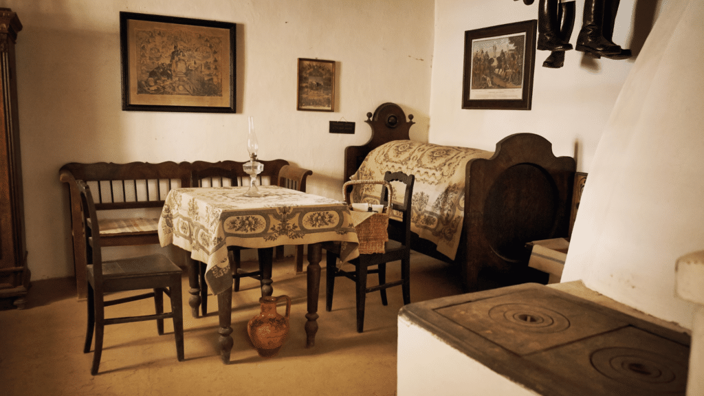 imagem do interior de uma casa antiga. Os móveis são antigos e de madeira. 