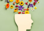 Representação de saúde mental. Cabeça de um boneco com flores coloridas.