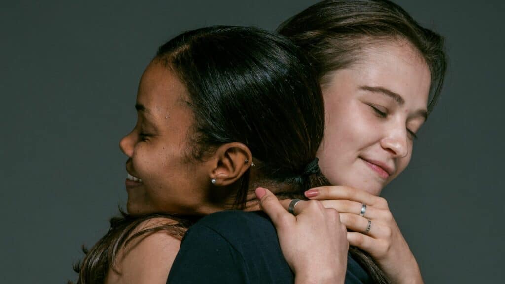 Imagem de duas mulheres se abraçando como se estivessem perdoando uma a outra