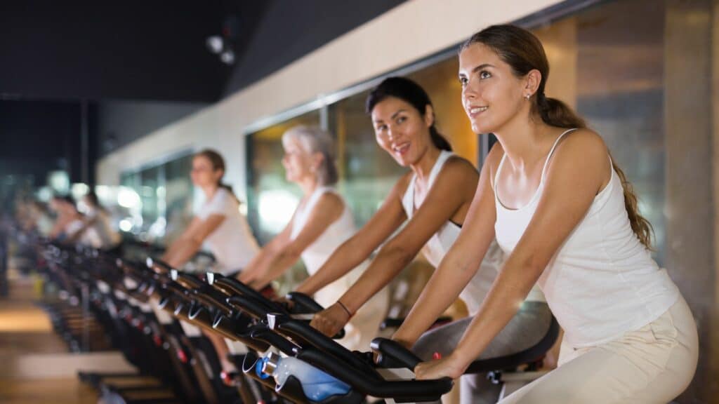 Imagem de mulheres treinando nas bicicletas na academia
