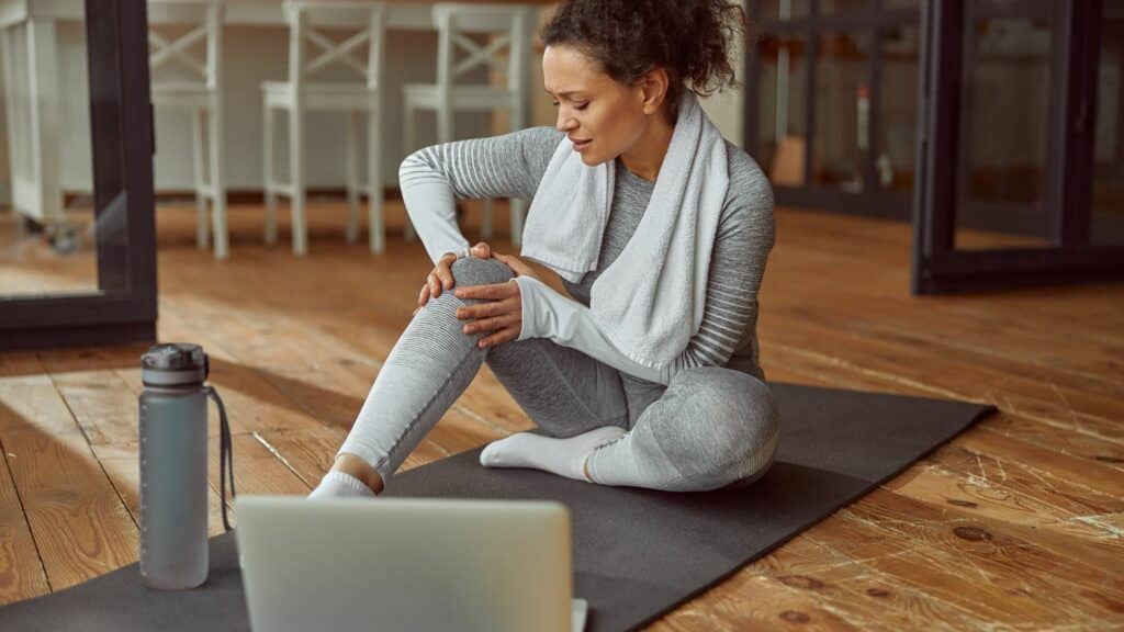 Mulher fazendo yoga com dor nos ossos.