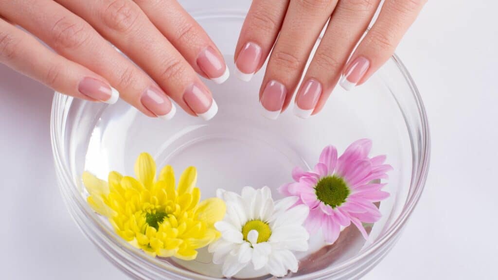 Mulher tocando em recipiente com flores.