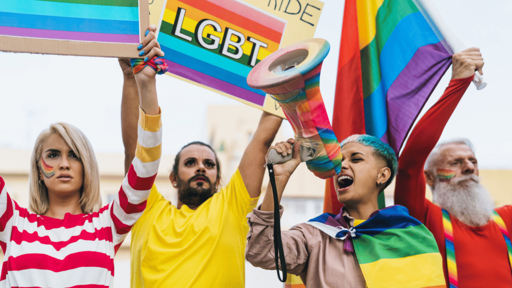 Pessoas protestando em uma Parada LGBTQIA+.