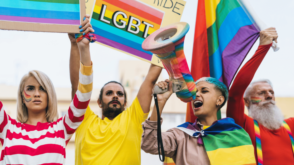 Pessoas protestando em uma Parada LGBTQIA+. 