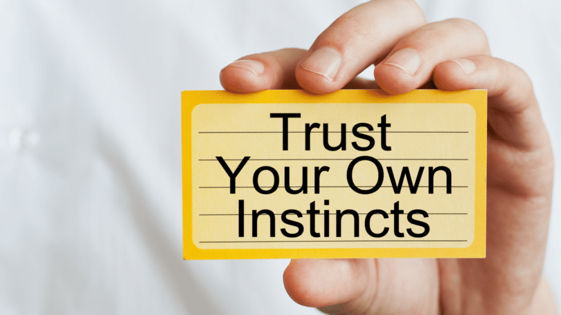 Imagem de uma mãos segurando um cartão amarelo, sinalizando uma mensagem: "Confie nos seus próprios instintos".