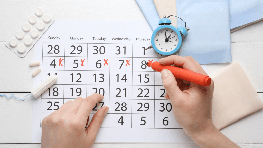 Pessoa escrevendo em um calendário menstrual