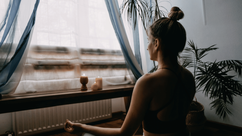 Mulher loira meditando em casa.