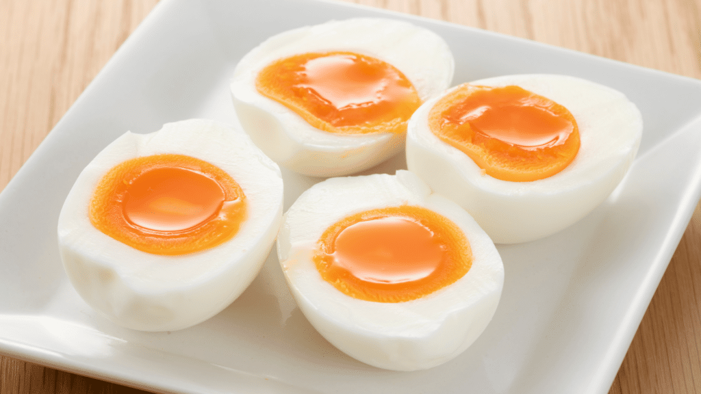 Imagem de ovos cozidos quentes em um prato branco. 
