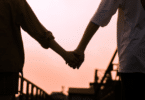 Casal de mãos dadas perto de uma ponte