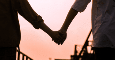 Casal de mãos dadas perto de uma ponte