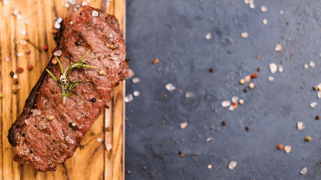 Carne assada temperada com sal grosso e um ramo de alecrim.