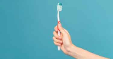 Imagem de uma escova de dente na mãe de uma pessoa em um fundo azul