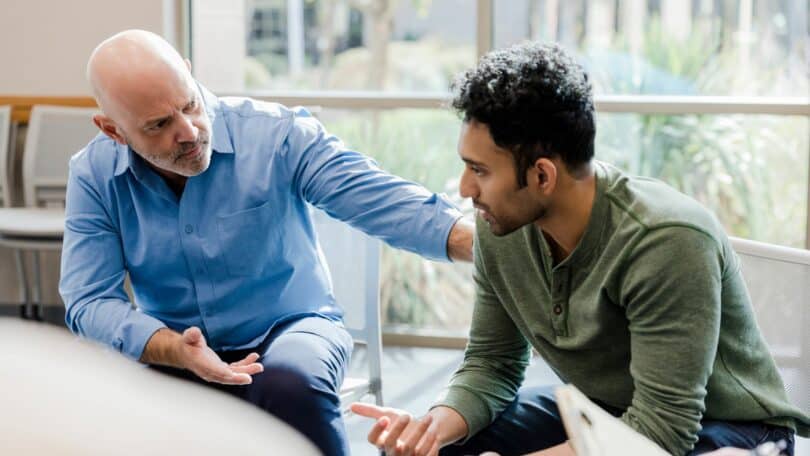 Imagem de um senhor conversando com um jovem em ato de empatia