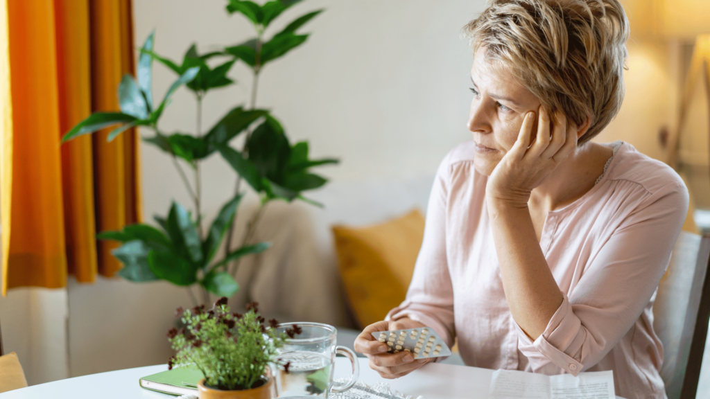 Mulher com feição de preocupada com sua menopausa. 