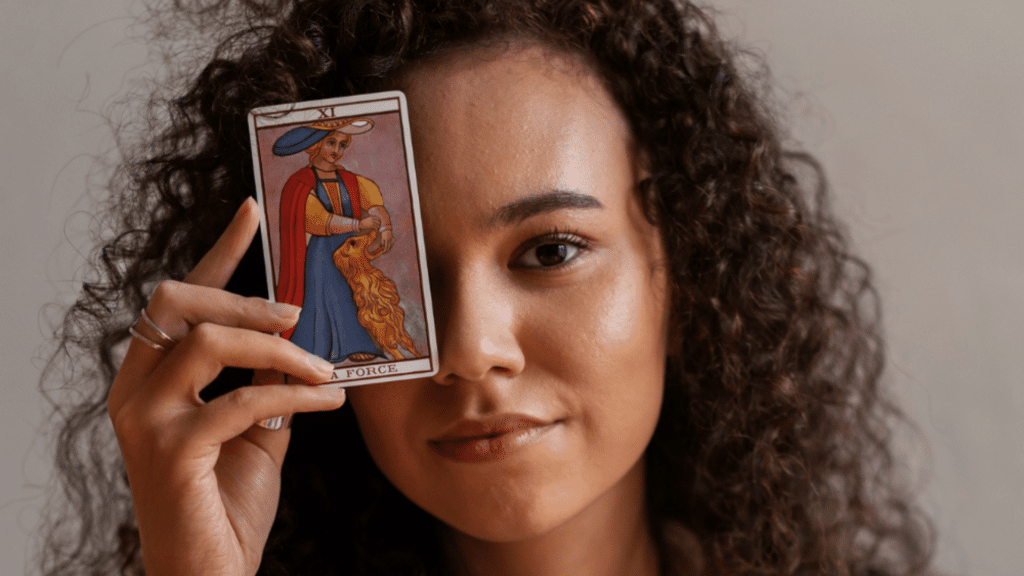 Mulher segurando carta de tarot "A força"