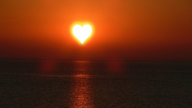 Sol de coração no mar