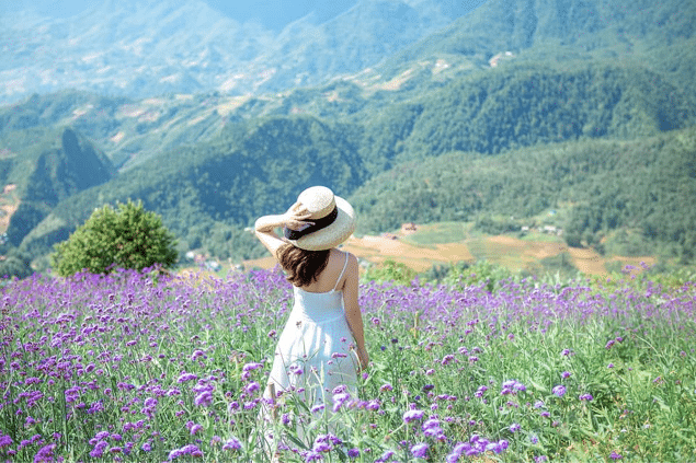 Mulher parada no meio de um campo de flores