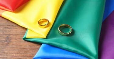 duas alianças sobre a bandeira LGBTQIA+