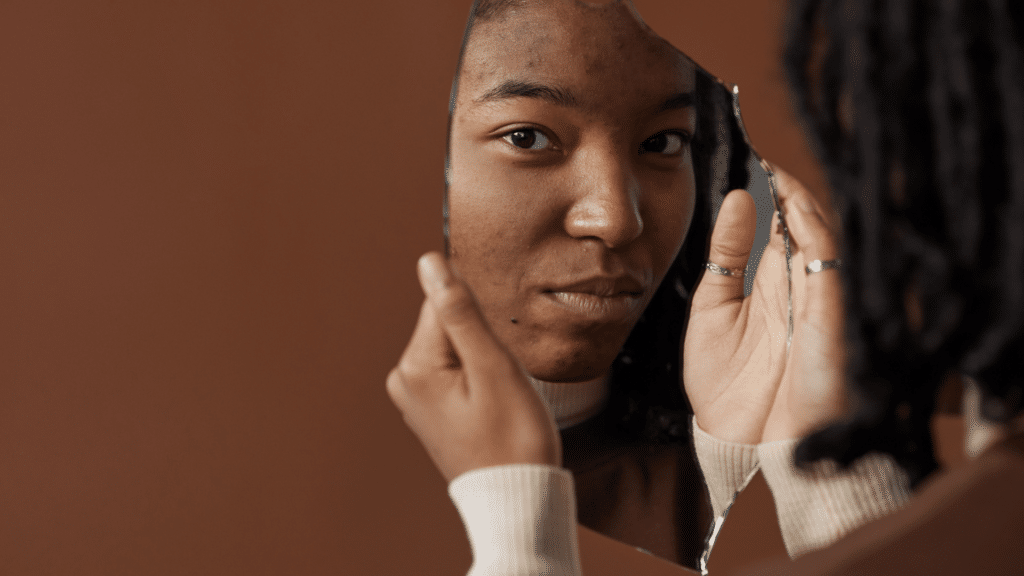 Reflexo de uma mulher negra no espelho.