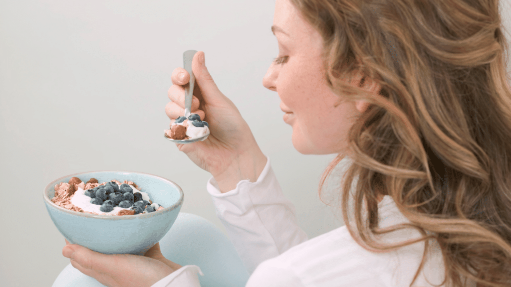 Mulher comendo um café da manhã saudável.
